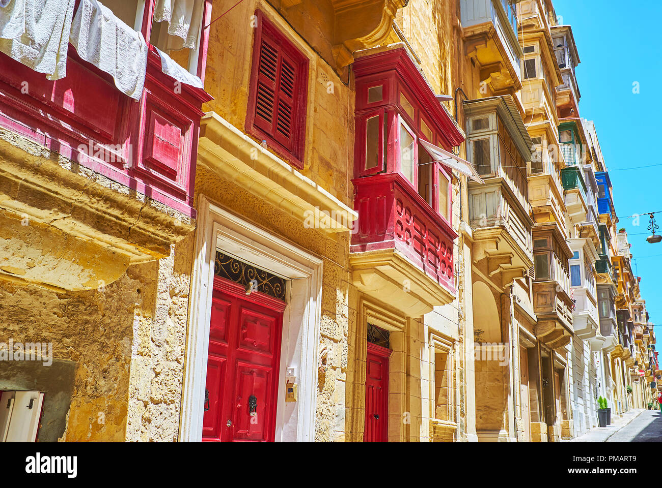 The city walk is the best choice to observe traditional Maltese balconies, decorated with patterns and painted in bright colors, Valletta, Malta. Stock Photo