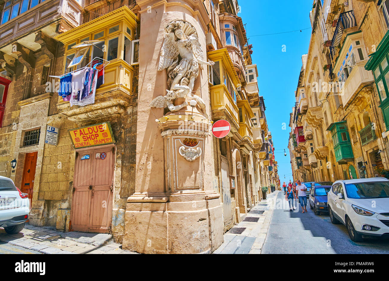 VALLETTA, MALTA - JUNE 17, 2018: Panorama of St Ursula street with the corner stucco statue of St Michael, fighting the devil, on June 17 in Valletta. Stock Photo