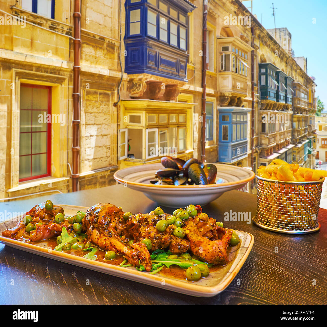 The restaurants of Strait street are best place to enjoy the famous rabbit stew, french fries, mussels and other traditional dishes of Maltese cuisine Stock Photo