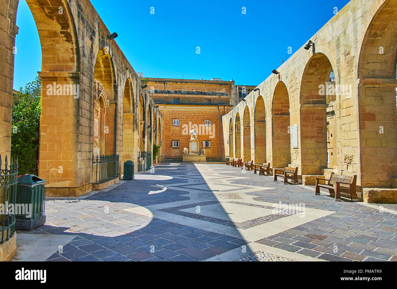 The picturesque terrace with arched walls and memorial statue in Upper Barrakka Gardens, Valletta, Malta. Stock Photo
