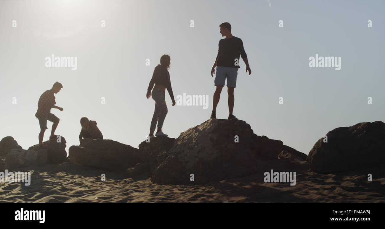 People Exploring Rocks Group of friends exploring rocks at the beach Stock Photo - Alamy