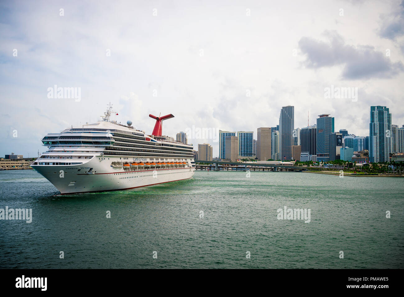 MIAMI, USA - CIRCA AUGUST, 2018: Carnival Victory cruise ship coming about to leave port with city skyline backdrop Stock Photo