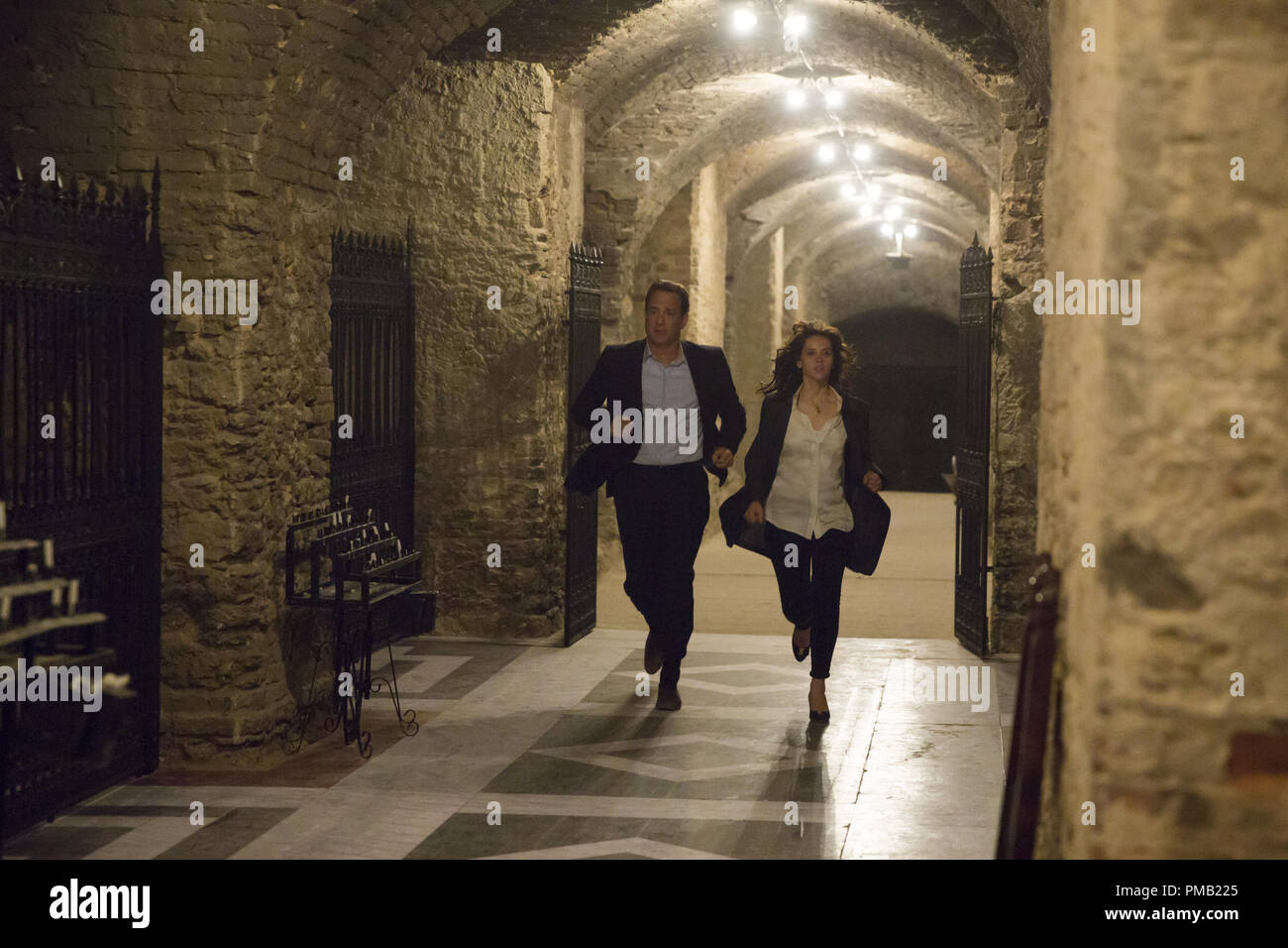 Langdon (Tom Hanks) and Sienna (Felicity Jones) run through the crypt of St Mark's Basilica in Columbia Pictures' INFERNO. Stock Photo