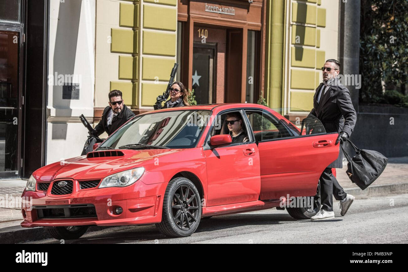 Baby (ANSEL ELGORT, in car), Buddy (JON HAMM, right), Darling (EIZA GONZALEZ), Griff (JON BERNTHAL, left) after their bank heist in TriStar Pictures' BABY DRIVER. (2017) Stock Photo