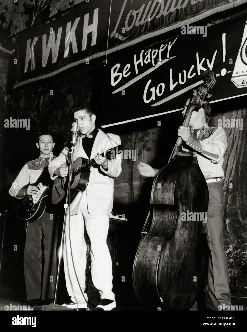 Teenager Elvis Presley at age 19, with Scotty Moore on the left and bass player Bill Black on the right, during a weekly broadcast of 'Lousiana Hayride' at the Shreveport Auditorium, 1954  File Reference # 33371 319THA Stock Photo