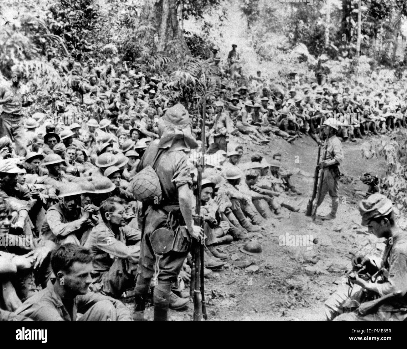 Japanese troops guard American prisoners of war at the beginning of the Bataan 'Death March', April 1942. Note Japanese photographer in the right foreground. Stock Photo