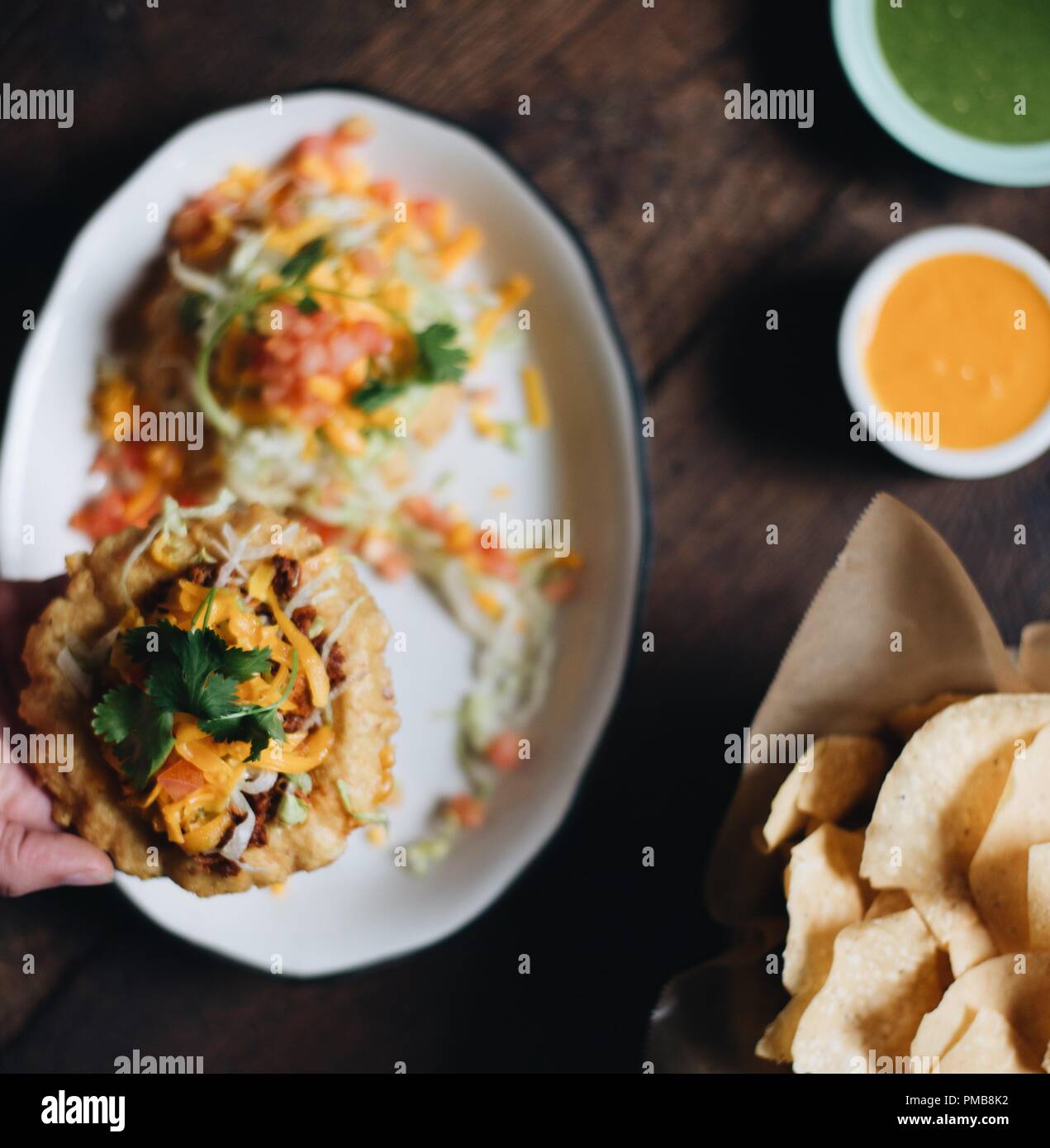 Tex-Mex meets fine dining with custom ceramic plates of traditional tex-mex dishes including puffy street corn tacos with verde and habanero salsas. Stock Photo