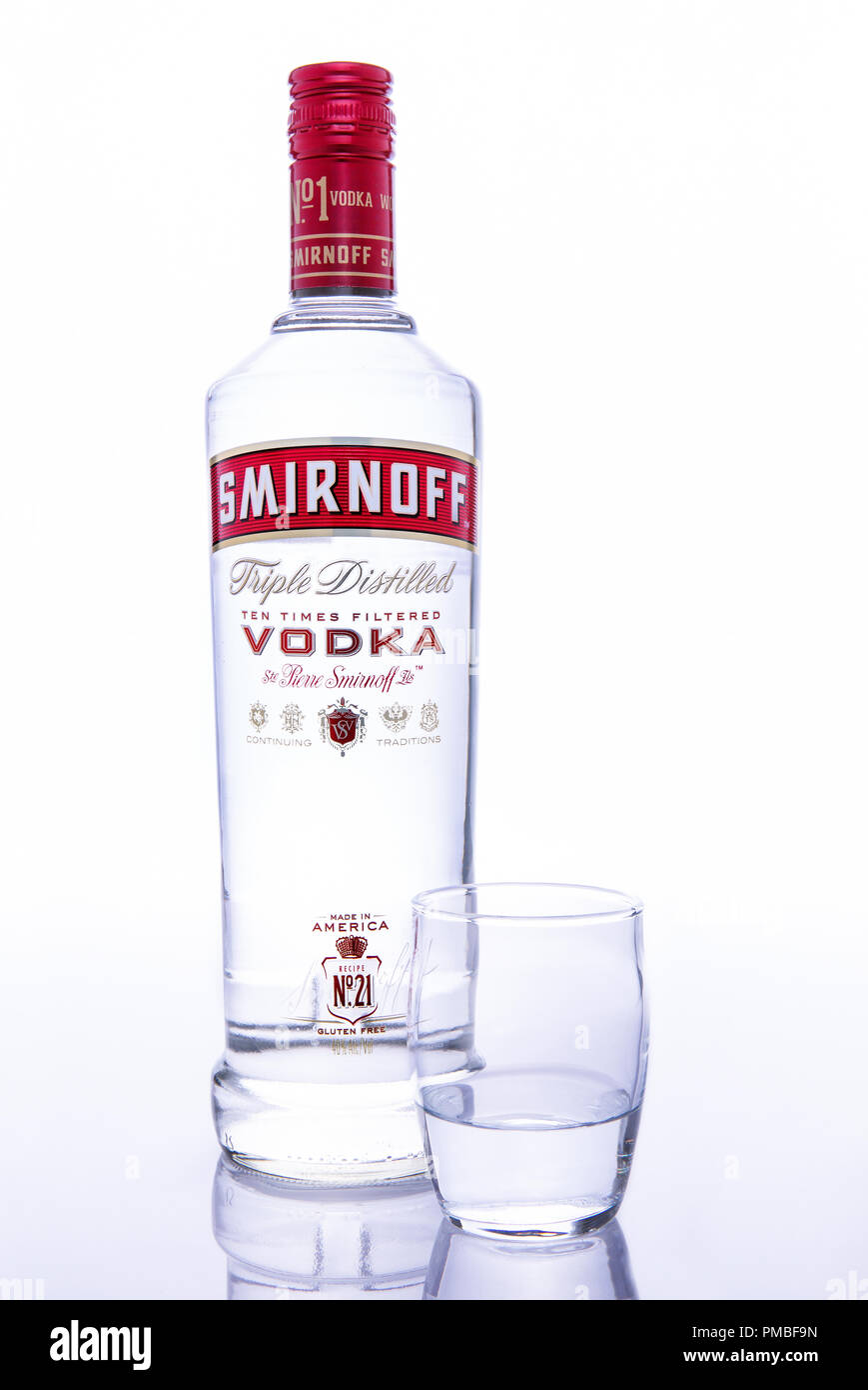 Bottle of Smirnoff vodka with shot glass against white background Stock Photo