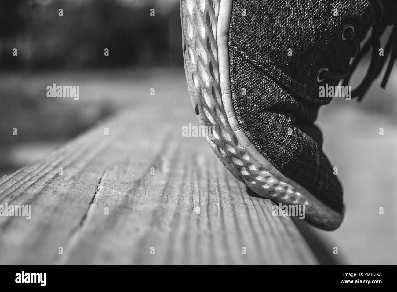 A Teenager Tiptoes On A Wooden Balancing Beam Ready To Jump At The School Training Yard On a Summer Day. Copy Space. Stock Photo