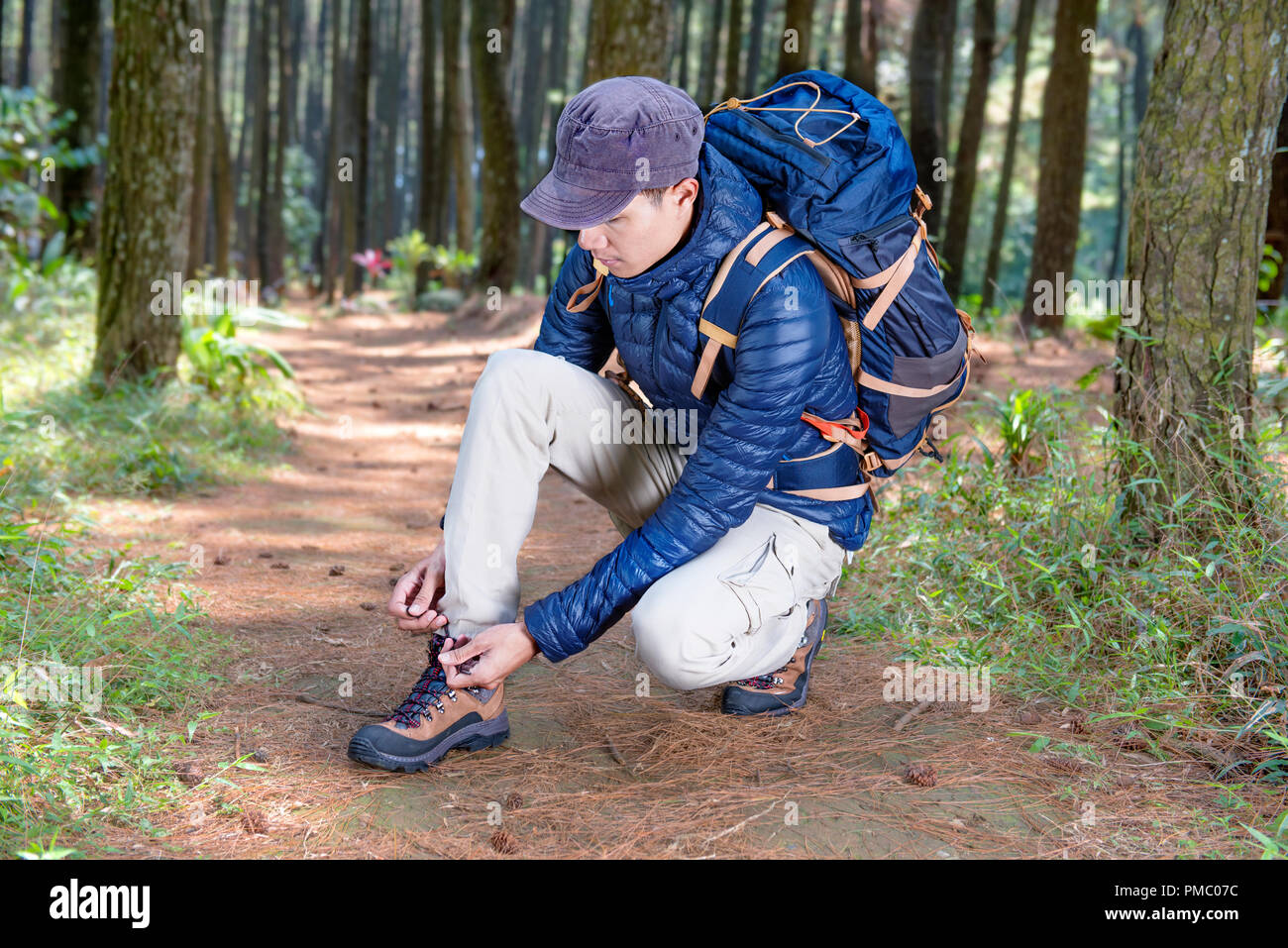 Portrait of asian traveler man tying shoelace before explore the forest Stock Photo