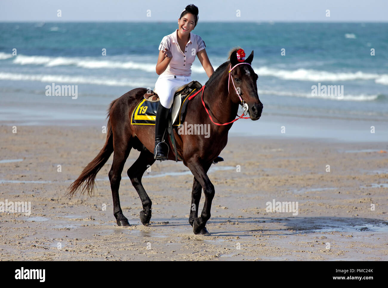 Woman horse riding beach. Female at a horse dressage and equestrian fashion event on Hua Hin beach Thailand Stock Photo