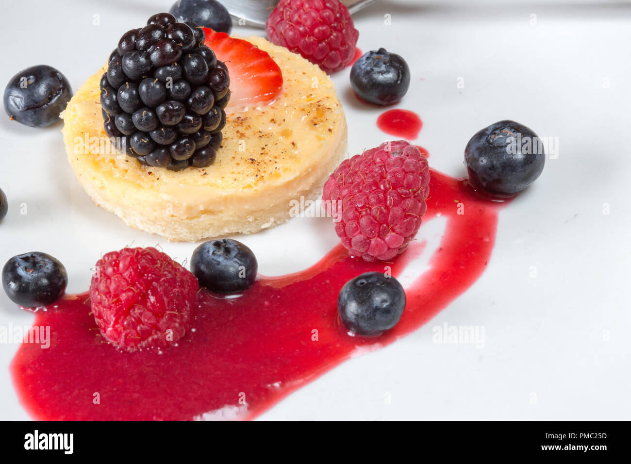 A serving of Egg custard tart with fresh strawberry, Raspberry and