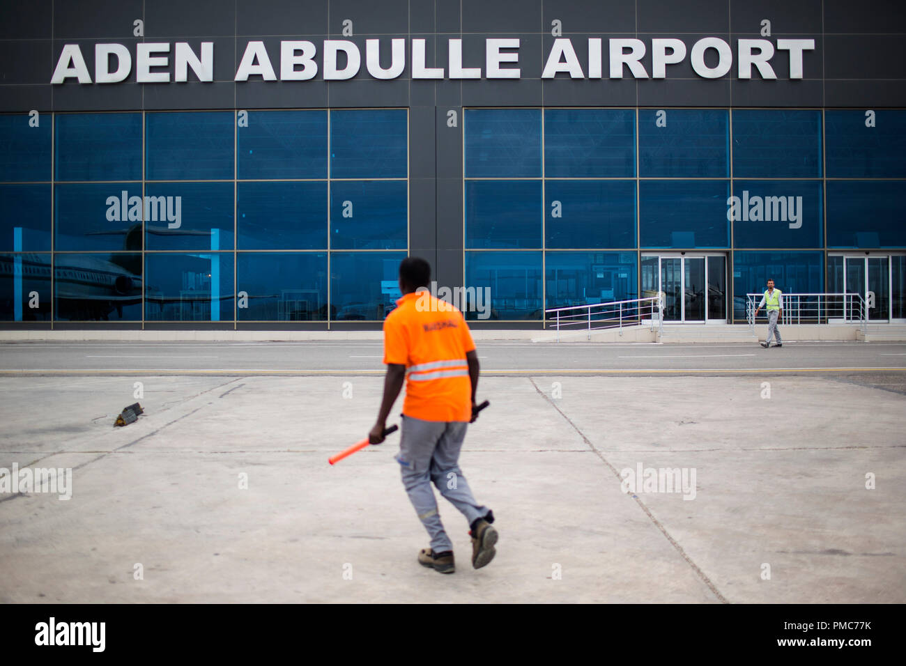 A marshaller walks through the runway by the newly built terminal of the Aden Abdulle airport inside the African Union Mission in Somalia (AMISOM) bas Stock Photo
