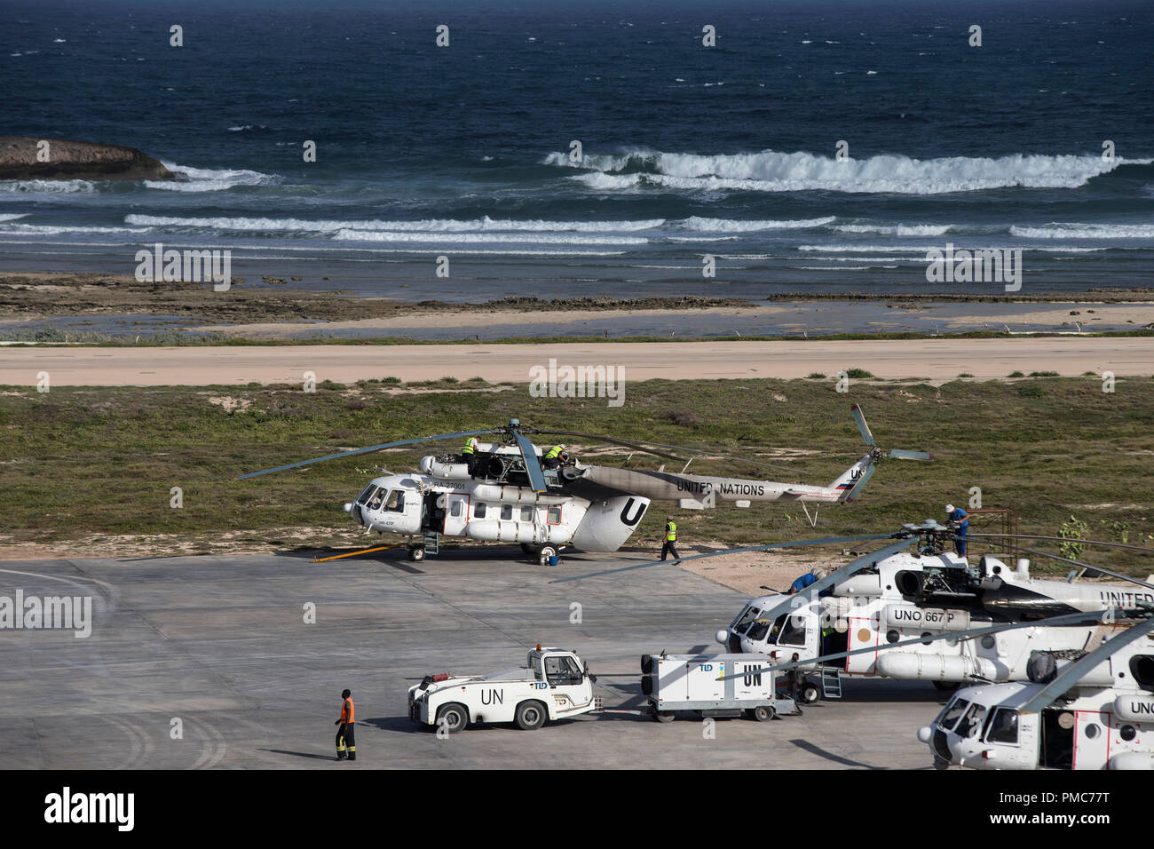 Aircraft and airport staff are seen on the tarmac of the Aden Abdulle airport inside the African Union Mission in Somalia (AMISOM) base in Mogadishu,  Stock Photo
