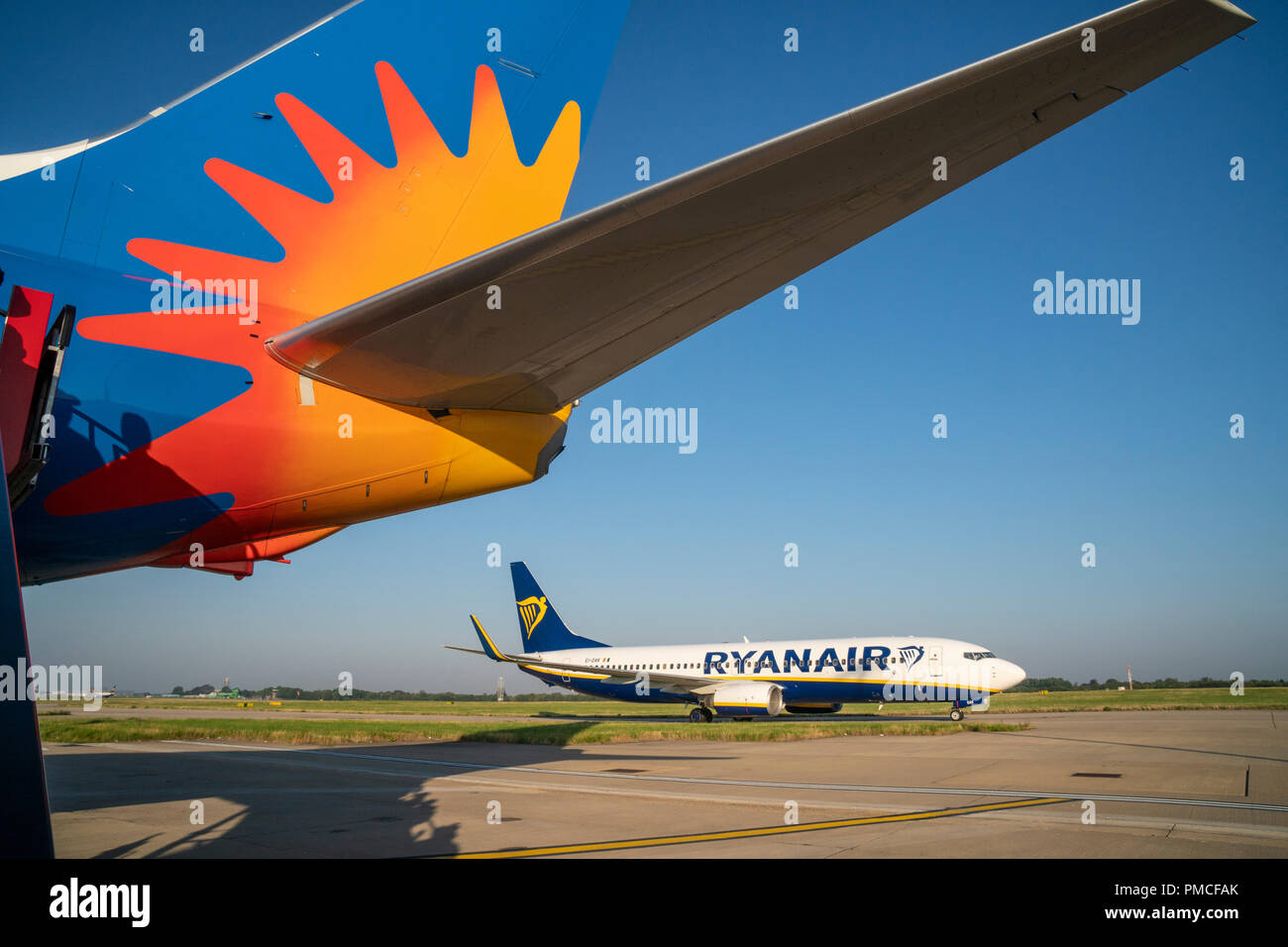 Ryanair aircraft passing by the tail of a rival Jet2 aircraft Stock Photo