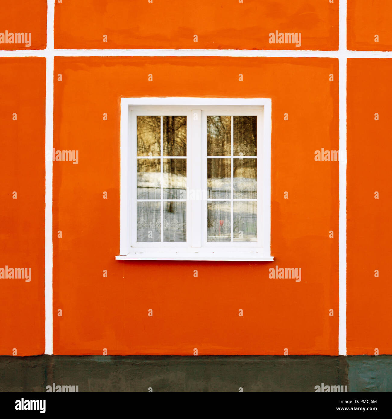 facade of a residential building, a window with a white frame and red ...