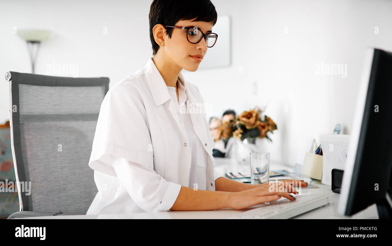 Charming female doctor typing on a keyboard Stock Photo