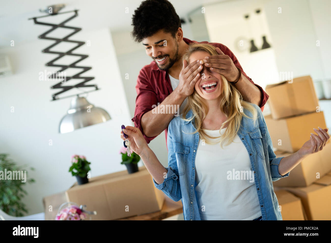 Young happy couple moving in new home and unpacking boxes Stock Photo ...