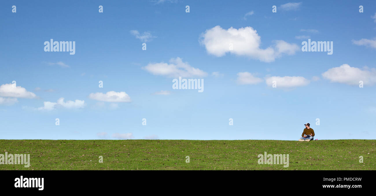 Man on a spacious meadow with a blue sky Stock Photo