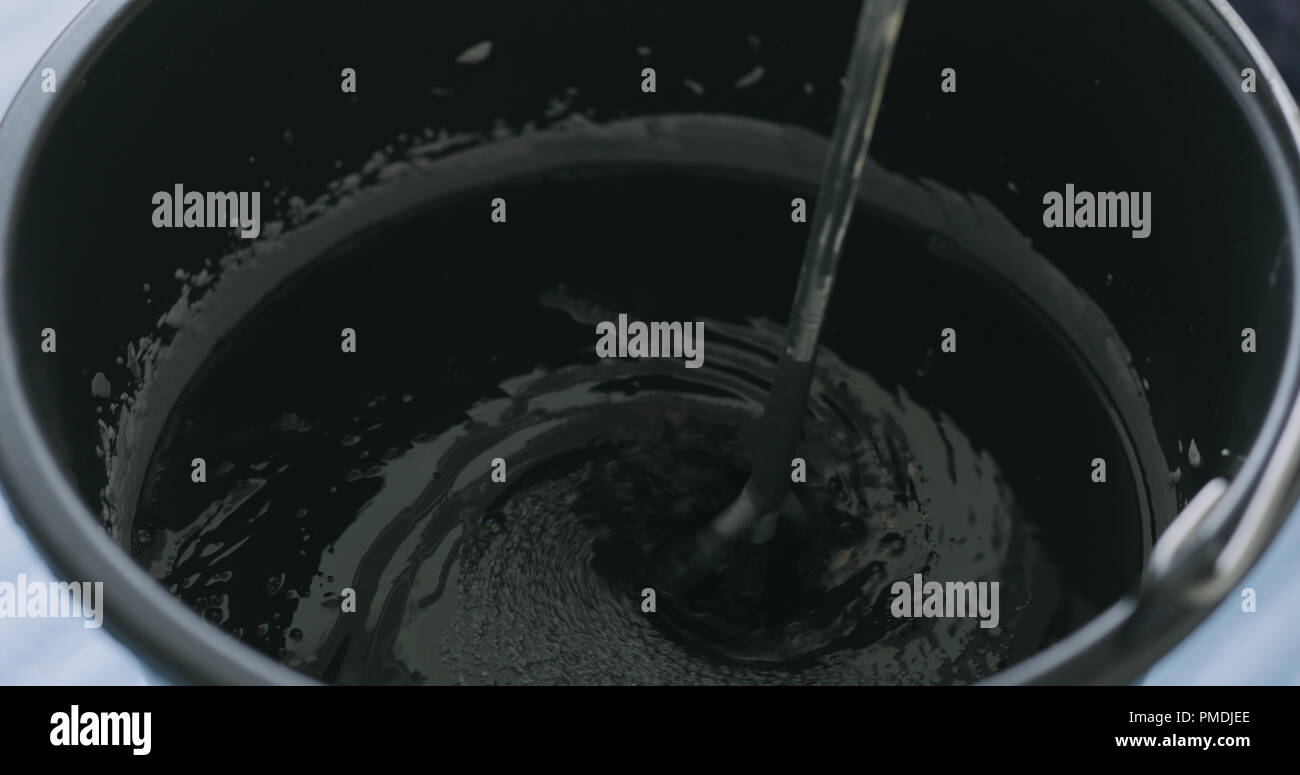 adding black ink to micro concrete plaster Stock Photo - Alamy