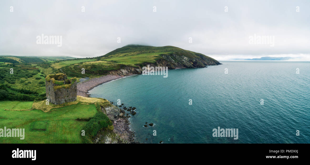 Aerial panorama of the Minard Castle situated on the rocky beach of the Dingle Peninsula with views across the Irish Sea in Kerry county, Ireland. Stock Photo