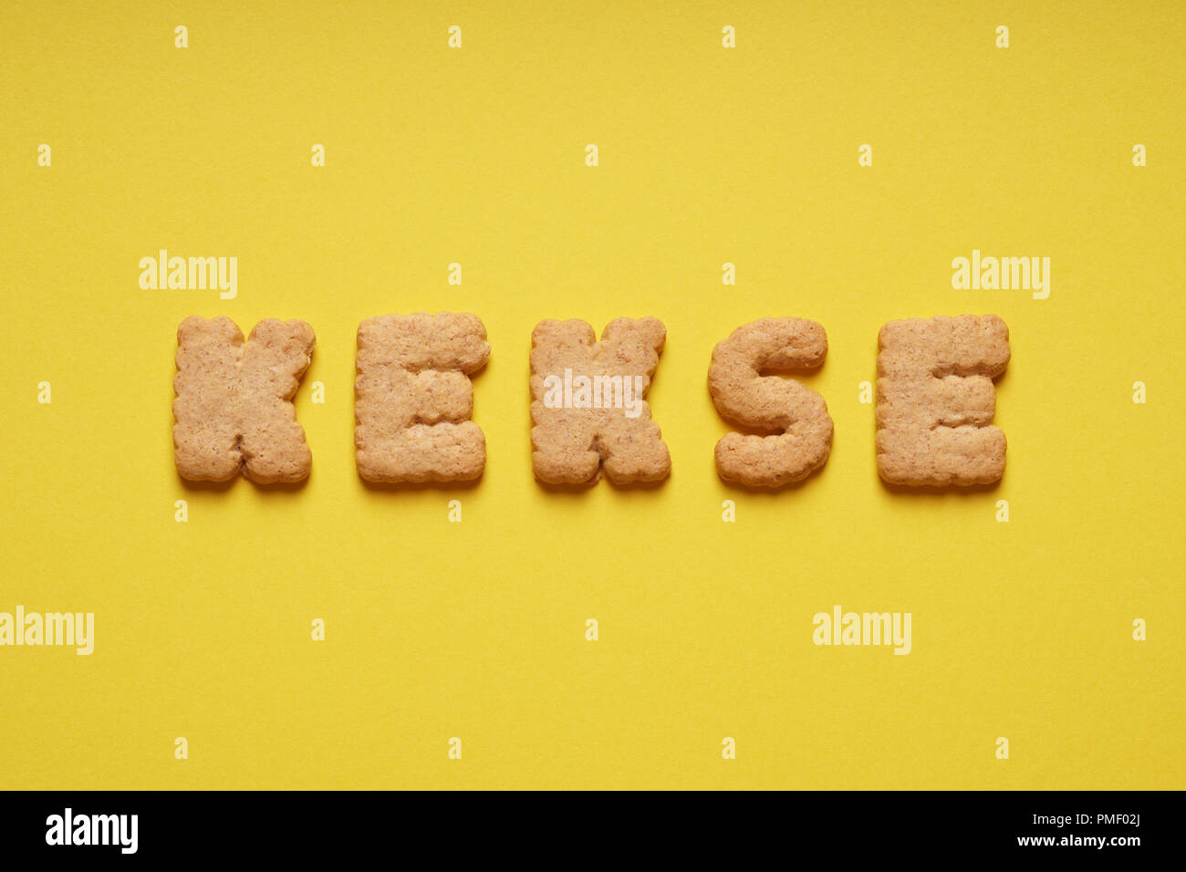 kekse is the german word for cookies or biscuits, spelled out with cookie letters or characters on yellow paper background Stock Photo