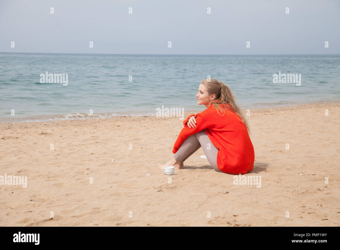 a woman walks by the Sea Beach one in autumn Stock Photo