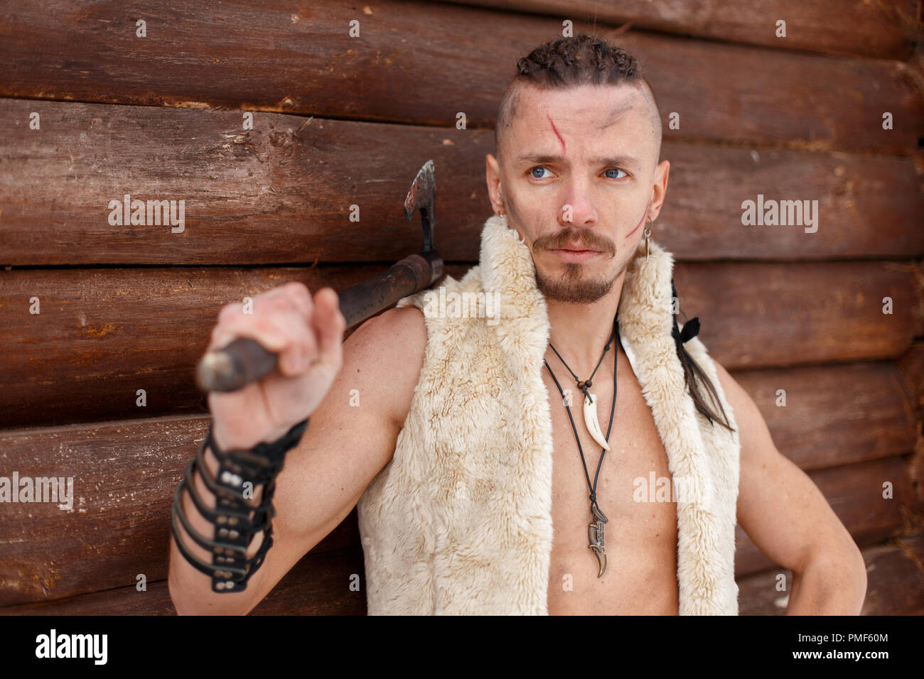 Viking with a scar with a hairstyle hold an ax in a vest of skin stands near a wooden wall Stock Photo - Alamy Viking with a scar with a hairstyle hold an ax in a vest of skin stands near a wooden wall Stock Photo - Alamy