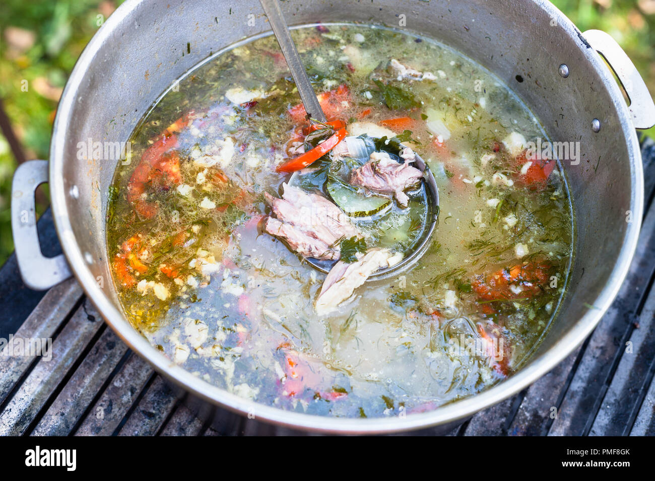 top view of pot with asian shurpa (soup from meat and large-sliced vegetables) outdoors Stock Photo