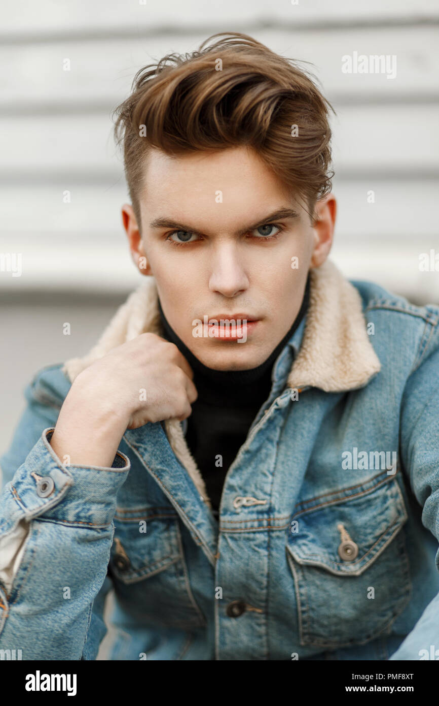 Fashion portrait of a handsome man with a haircut in a jeans jacket on the street Stock Photo