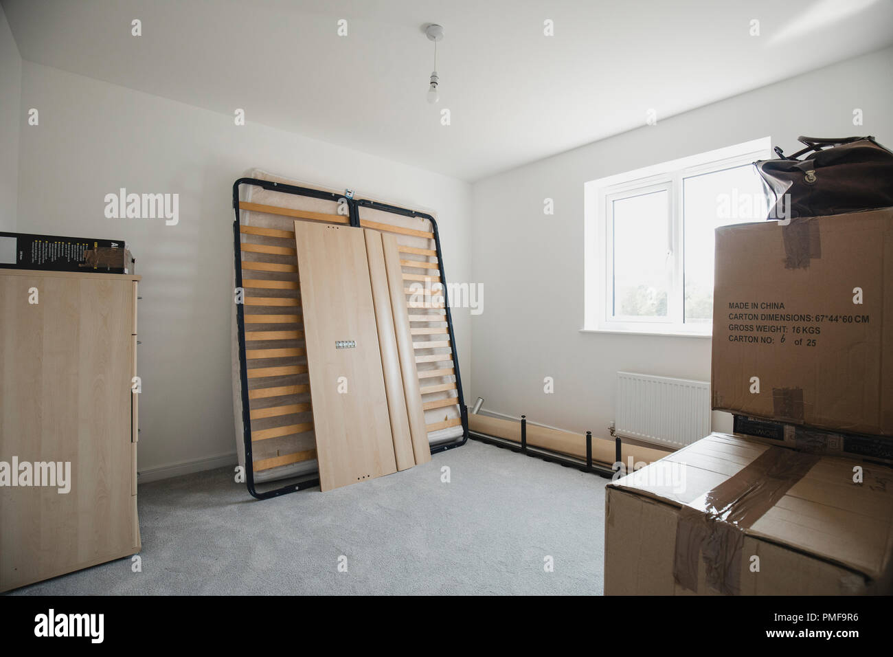 Bedroom of a new home with flatpack furniture and cardboard boxes. Stock Photo