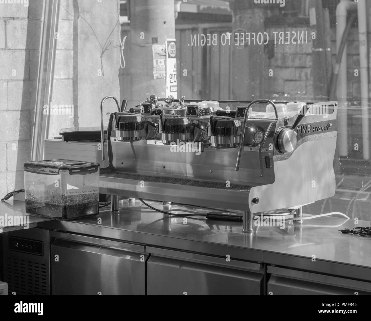 Shot of an espresso machine in black and white, in front of a glass window in the popular Onion Cafe, Seongdong-gu neighborhood, Seoul, South Korea Stock Photo