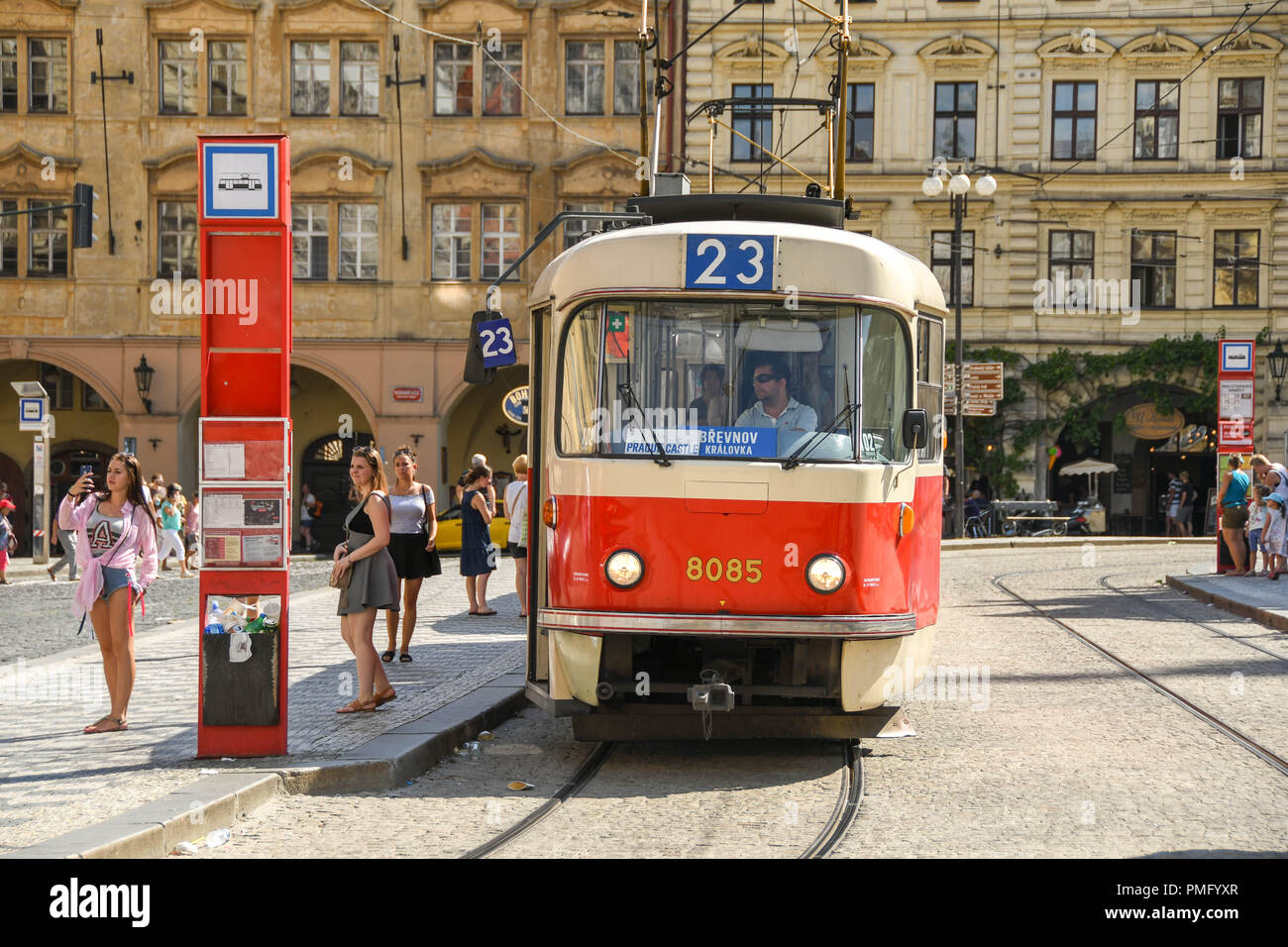 people alongside a tram at a tram stop on a street in the centre of Prague Stock Photo