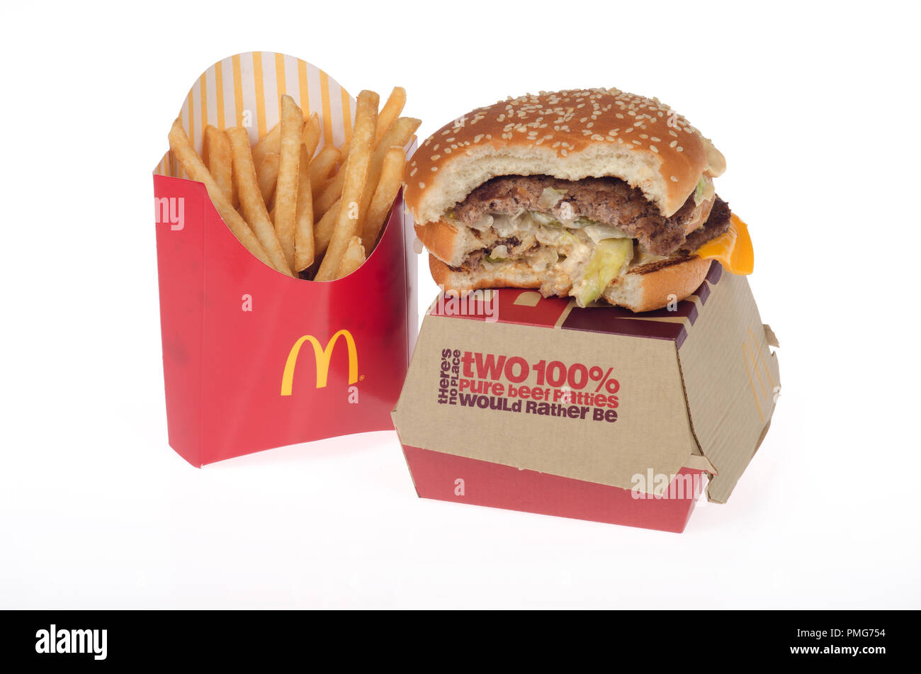 McDonald’s Big Mac with a bite taken out on top of box with french fries or chips Stock Photo