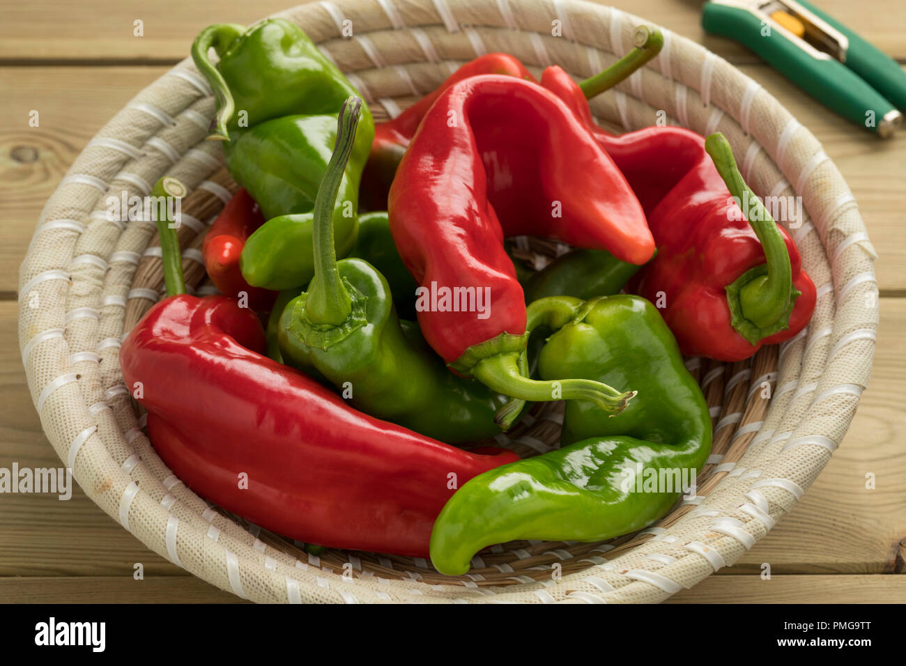 Basket with fresh picked natural shaped organic red and green fresh pointed bell ppepers Stock Photo