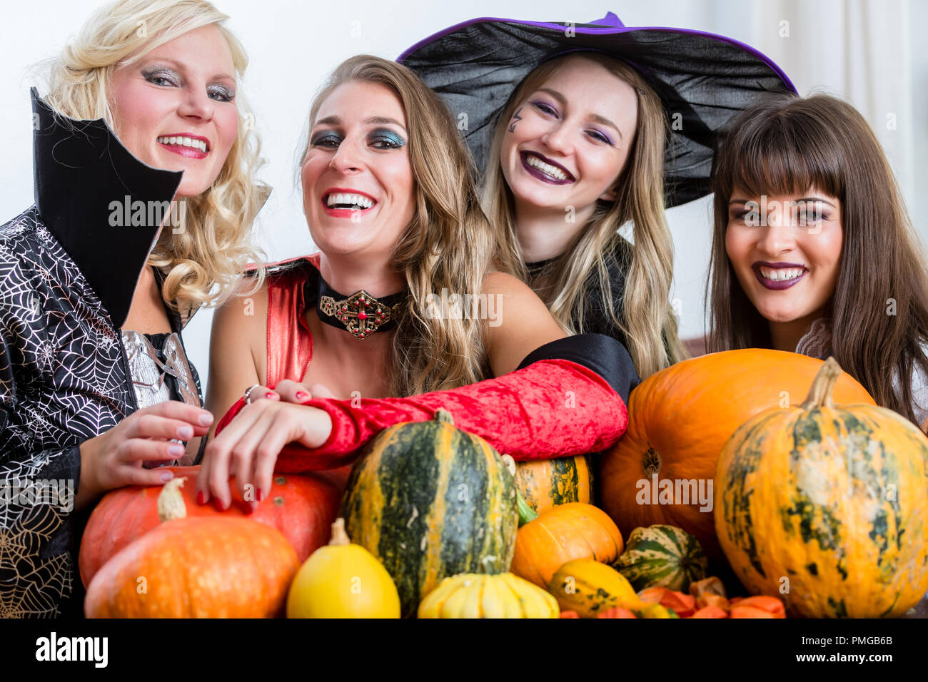 Four cheerful women celebrating Halloween together Stock Photo