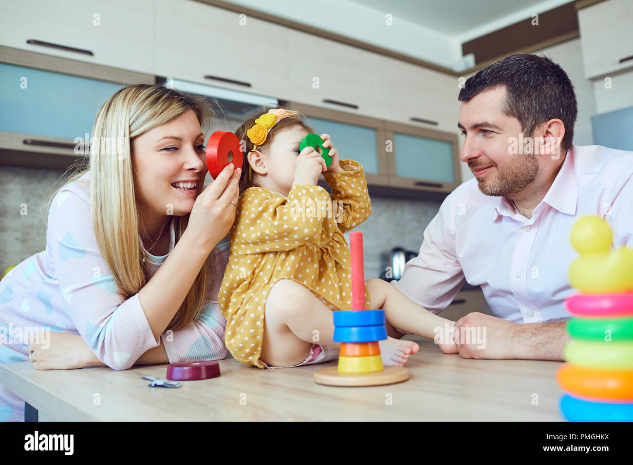 Mother, father and child are playing in the room . Stock Photo