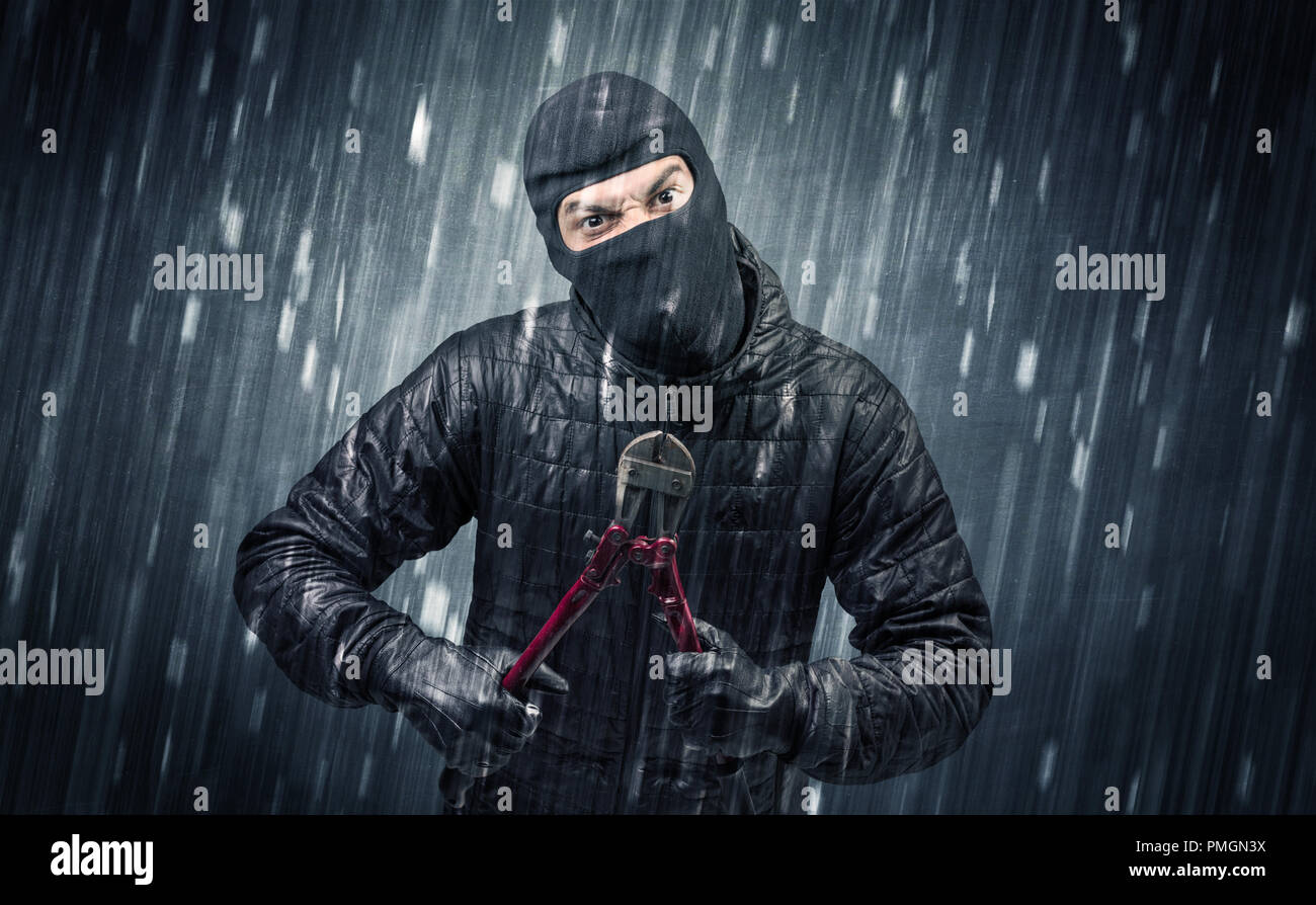 Burglar in action in black clothes with rainy concept Stock Photo Alamy