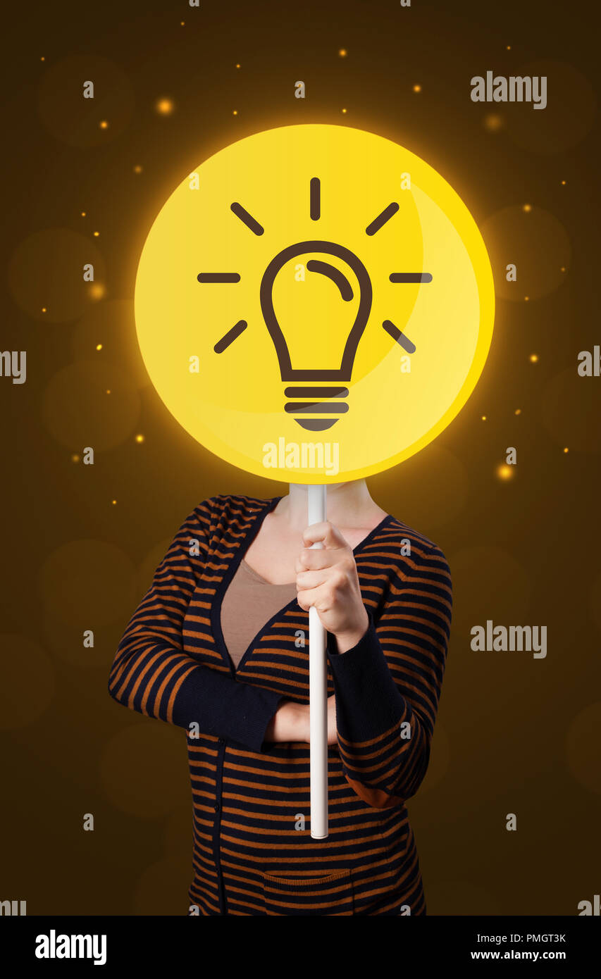 Casual young woman holding round sign with yellow lightbulb Stock Photo