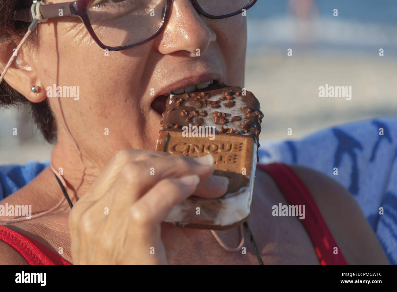 Italy Calabria Middle-aged woman at the seaside while eating ice cream close-up Stock Photo