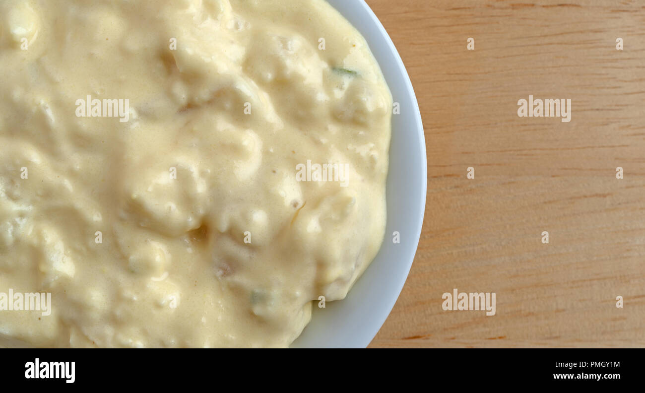 Top close view of a portion of potato and egg salad in a small bowl on