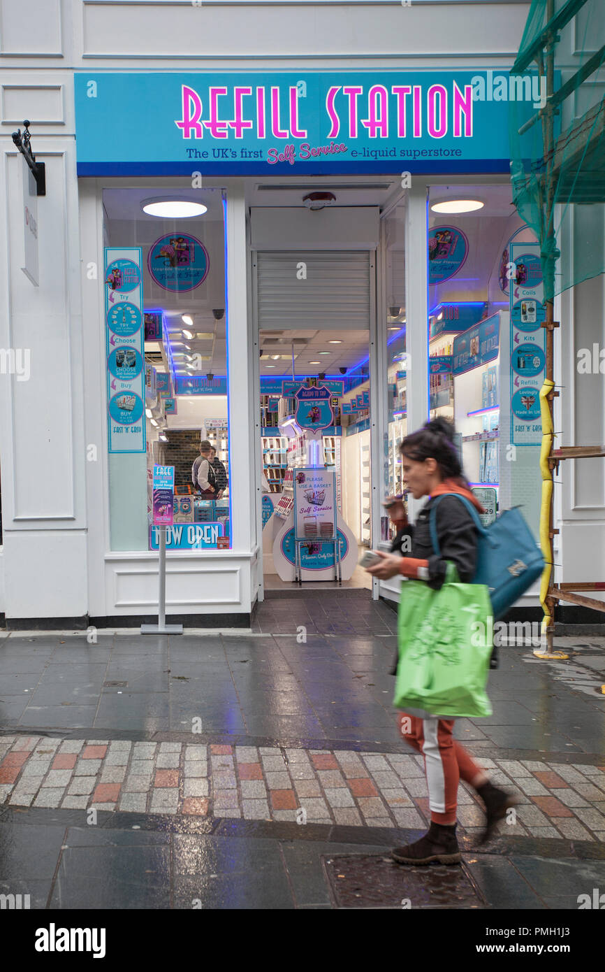 Smoker passing Refill Station, retail Vape store, cigarette shop in Dundee,  City centre, Scotland. UK Stock Photo