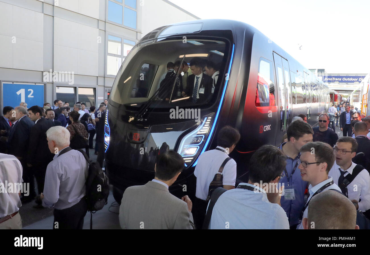 18 September 2018, Berlin: At the Innotrans railway trade fair, people are standing in front of a Chinese metro train of the company CRRC in lightweight construction. The train will be presented in a world premiere on the exhibition grounds between the halls under the radio tower. A Saxon company was involved in the development of the train. Photo: Wolfgang Kumm/dpa Stock Photo