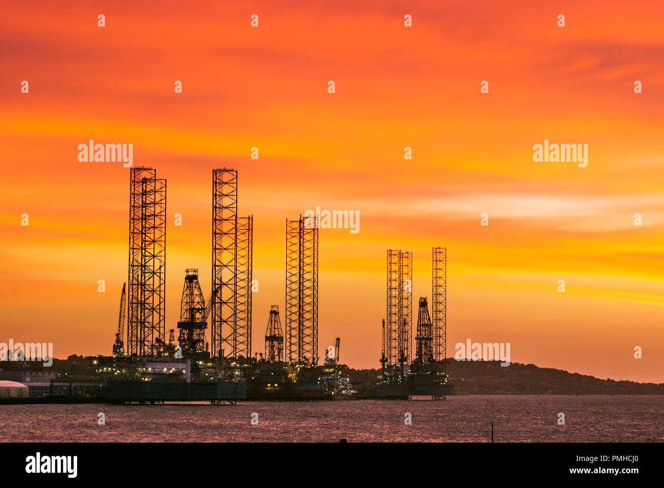 Jack up rigs oil and gas industry in the Port of Dundee, Scotland. UK Weather Sep 2018.  Colourful start to the day at Tayside Docks where three jack-up rigs, oil rig platforms are undergoing service and maintenance at the riverside facility on the River Tay estuary.  The slowdown in the North Sea oil and gas industry has led to oil rigs being removed from the North Sea, with Dundee docklands providing a berthing place for them until they are required again in the future. Credit; MediaWorldNews/AlamyLiveNews. Stock Photo