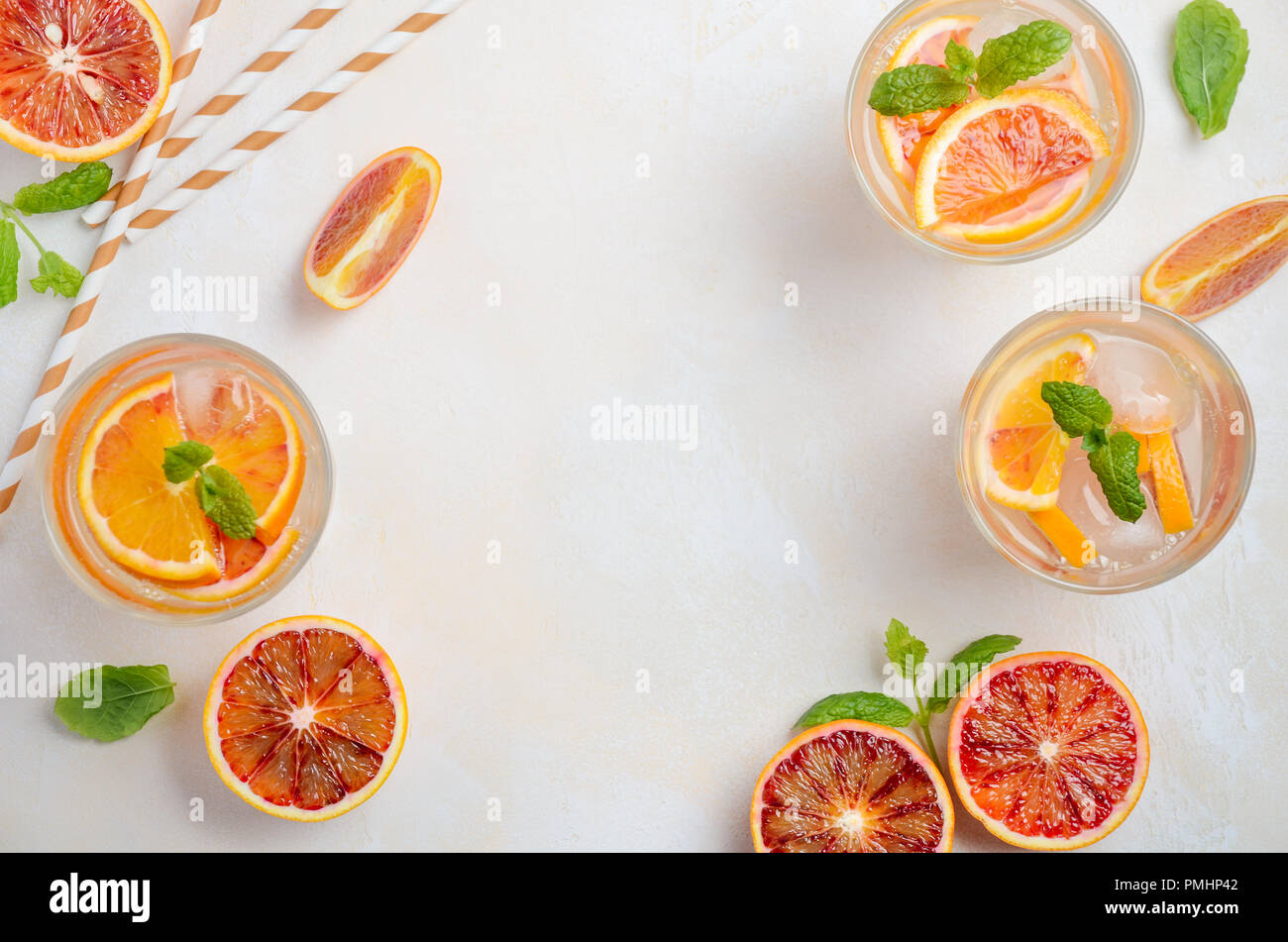 Cold refreshing drink with blood orange slices in a glass on a white concrete background. Top view, flat lay, copy space. Stock Photo