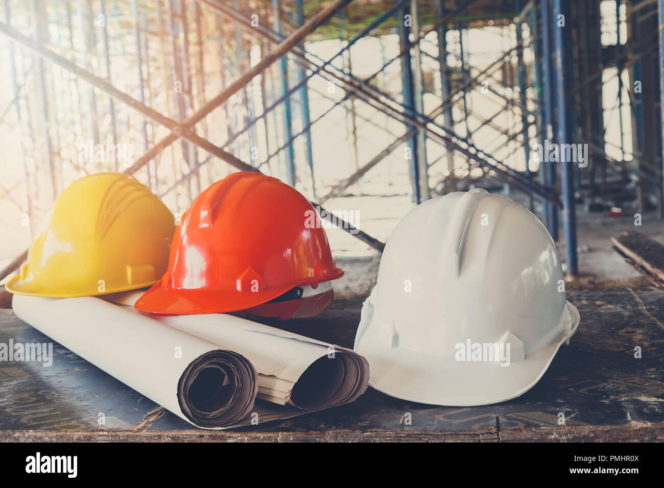 Helmet and blueprint on table in construction site Stock Photo - Alamy