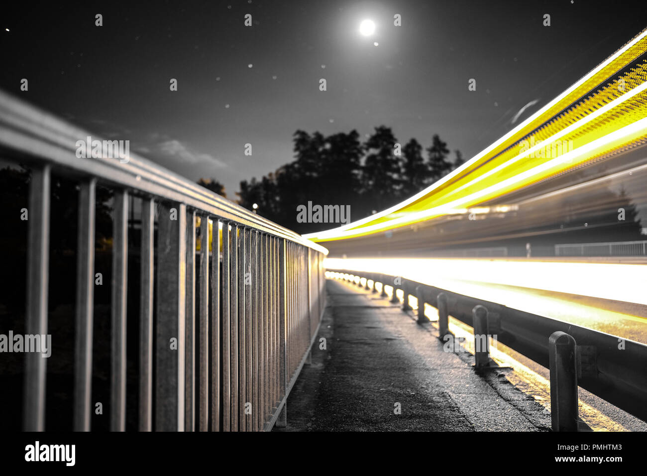 Long exposure shot of the Schiffenen dam in the county of Fribourg, in Switzerland, with vehicle light trails on the side Stock Photo