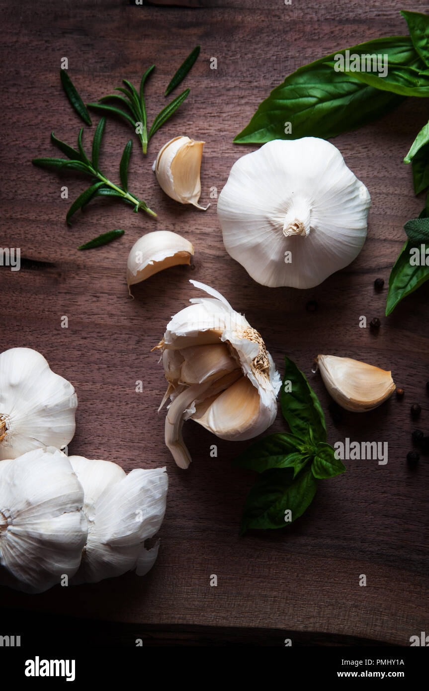 garlic clove and herbs on a wooden background Stock Photo - Alamy