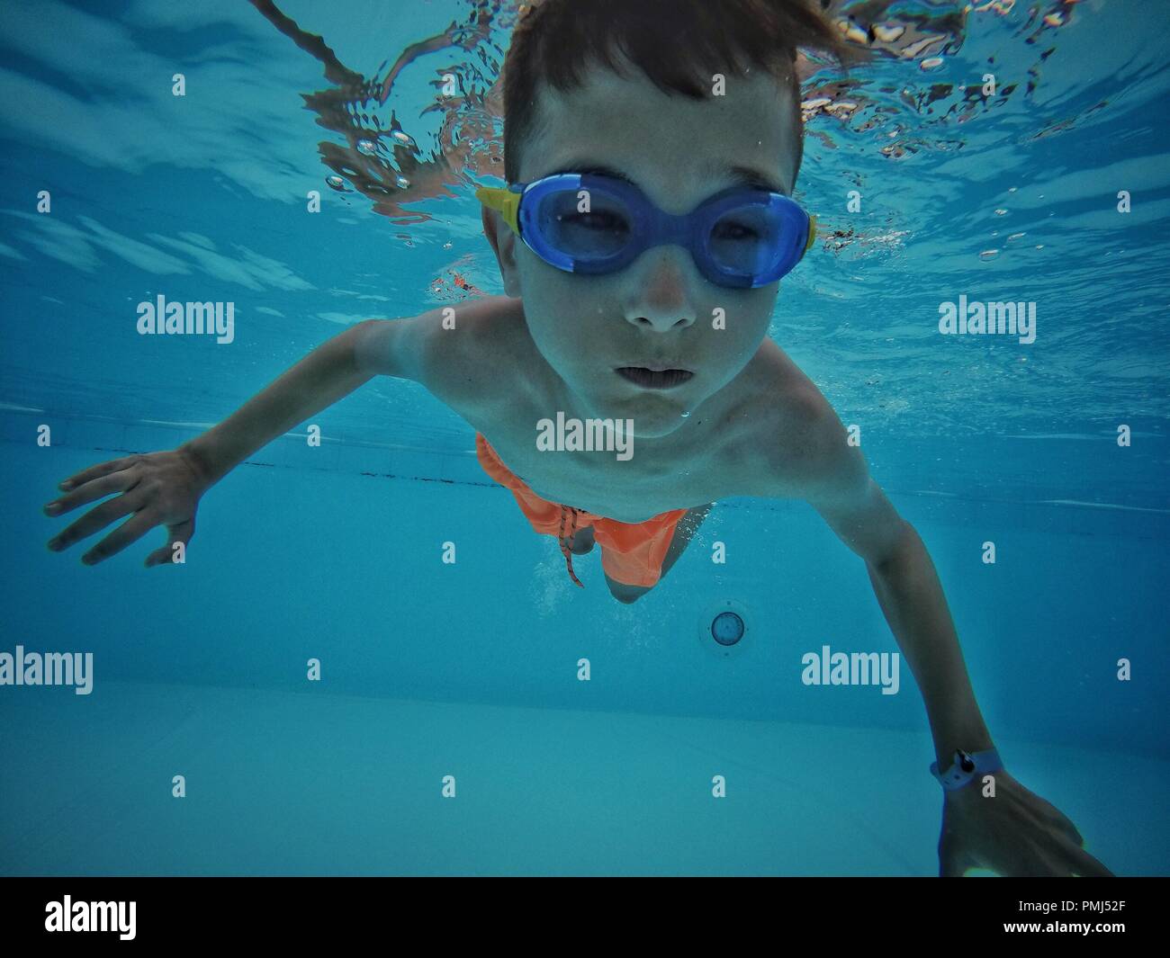 Boy swimming underwater in a swimming pool Stock Photo