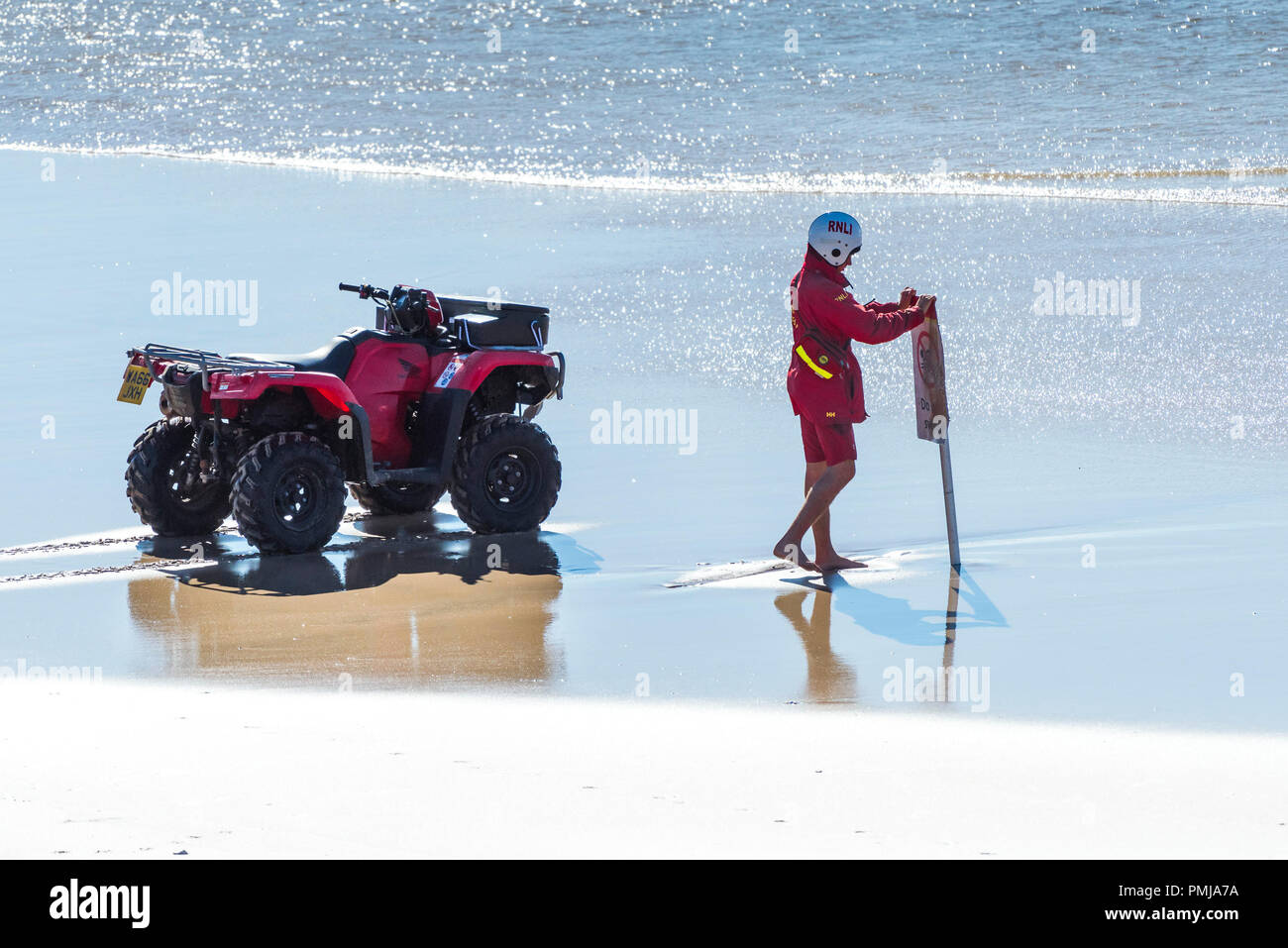 A RNLI Lifeguard placing a Do Not Swim warning sign on Fistral Beach in Newquay Cornwall. Stock Photo